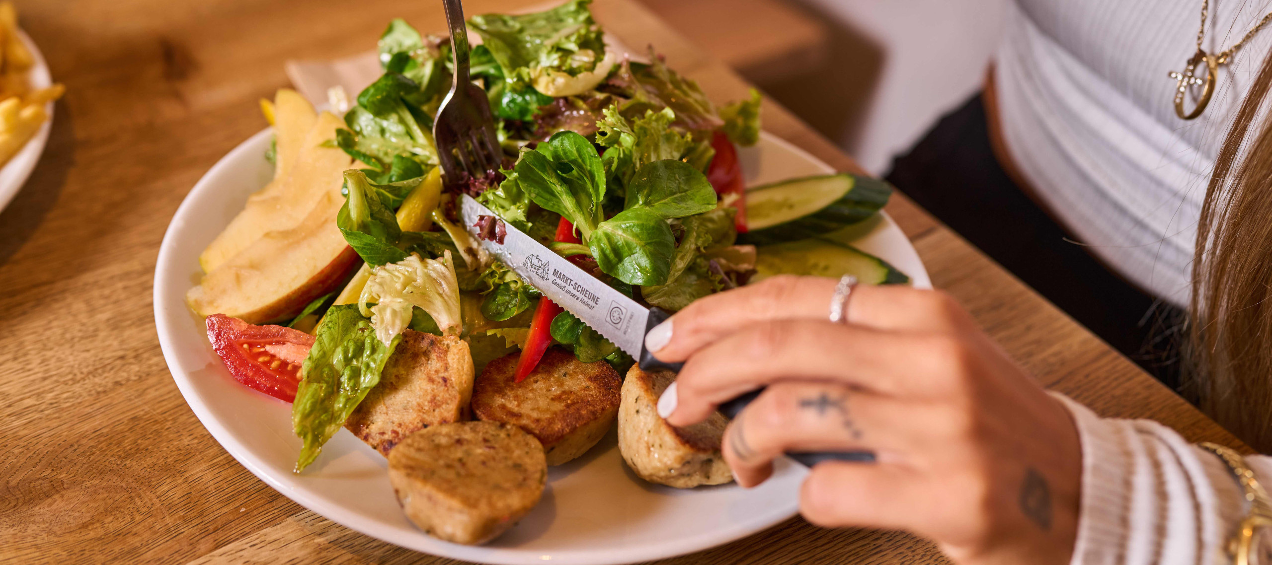 runder Teller mit großer Salatportion und hausgemachten Knödelscheiben